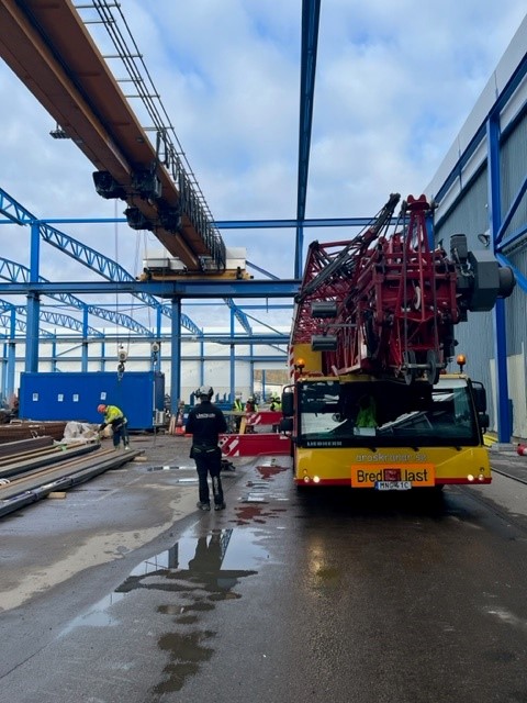 gul och röd lyftkran och person som kollar