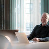 Glad man som sitter vid en dator