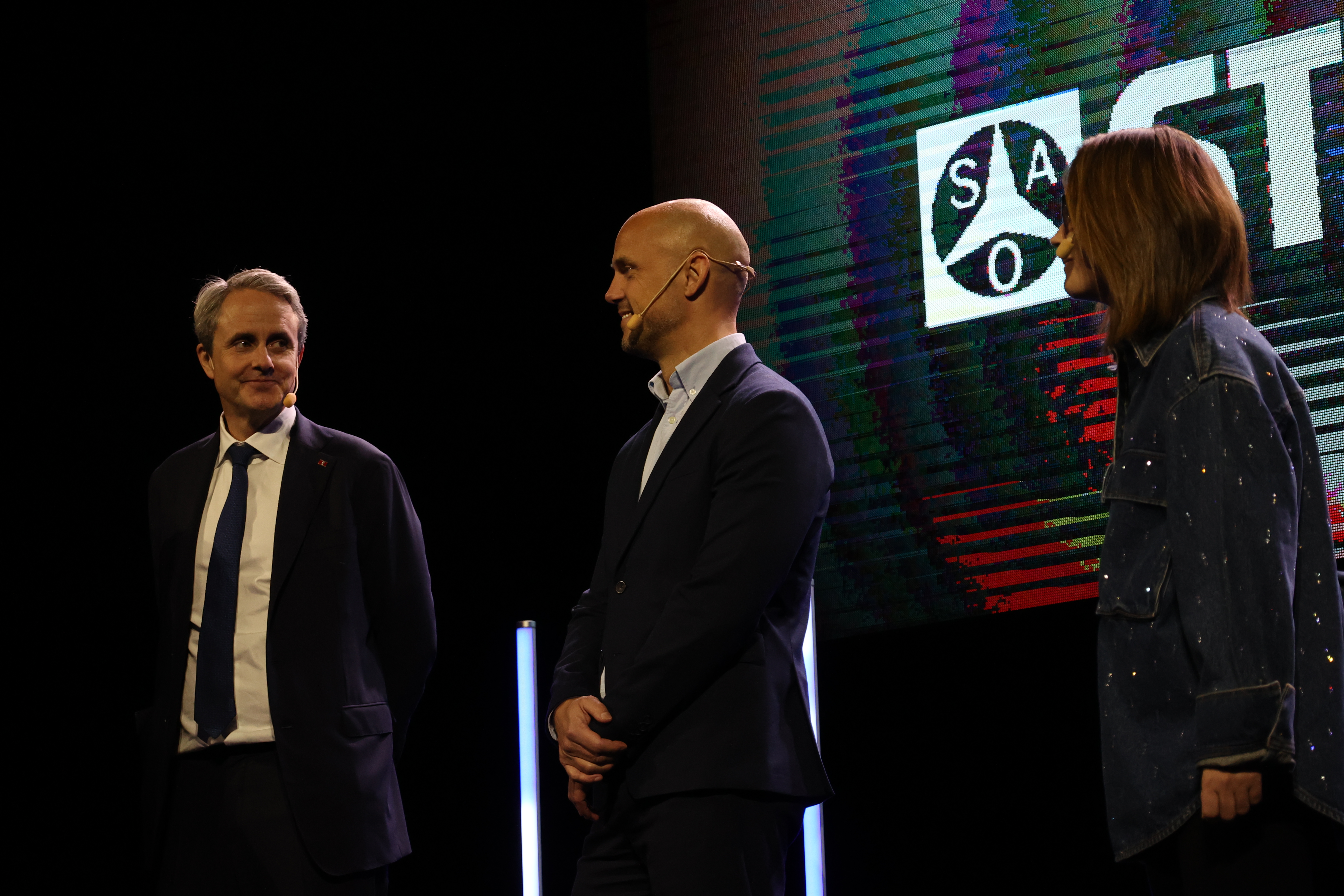 Three people standing on a stage
