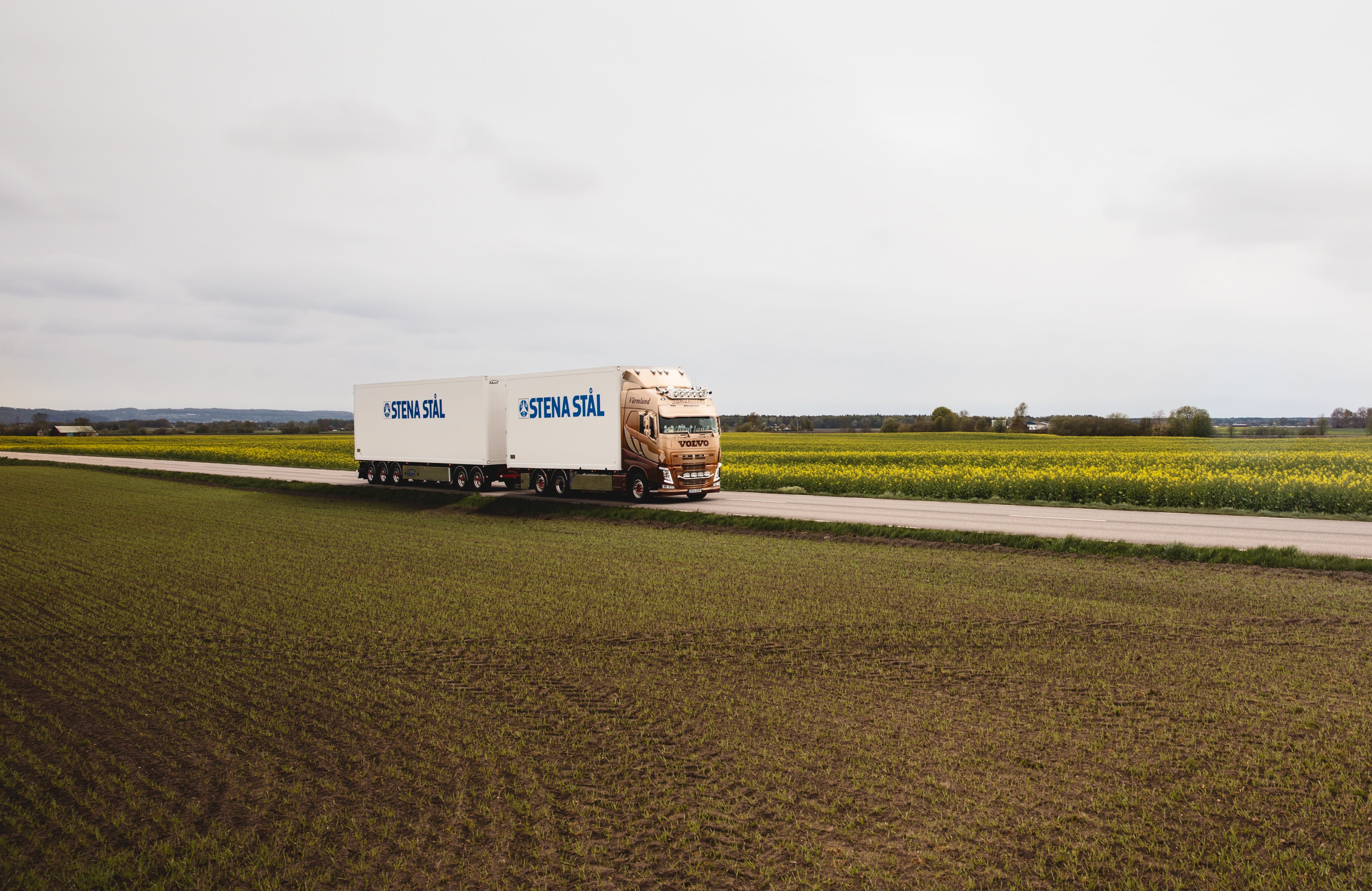 En Stena Stål lastbil som gör genom solnedgången på en landsväg i Sverige