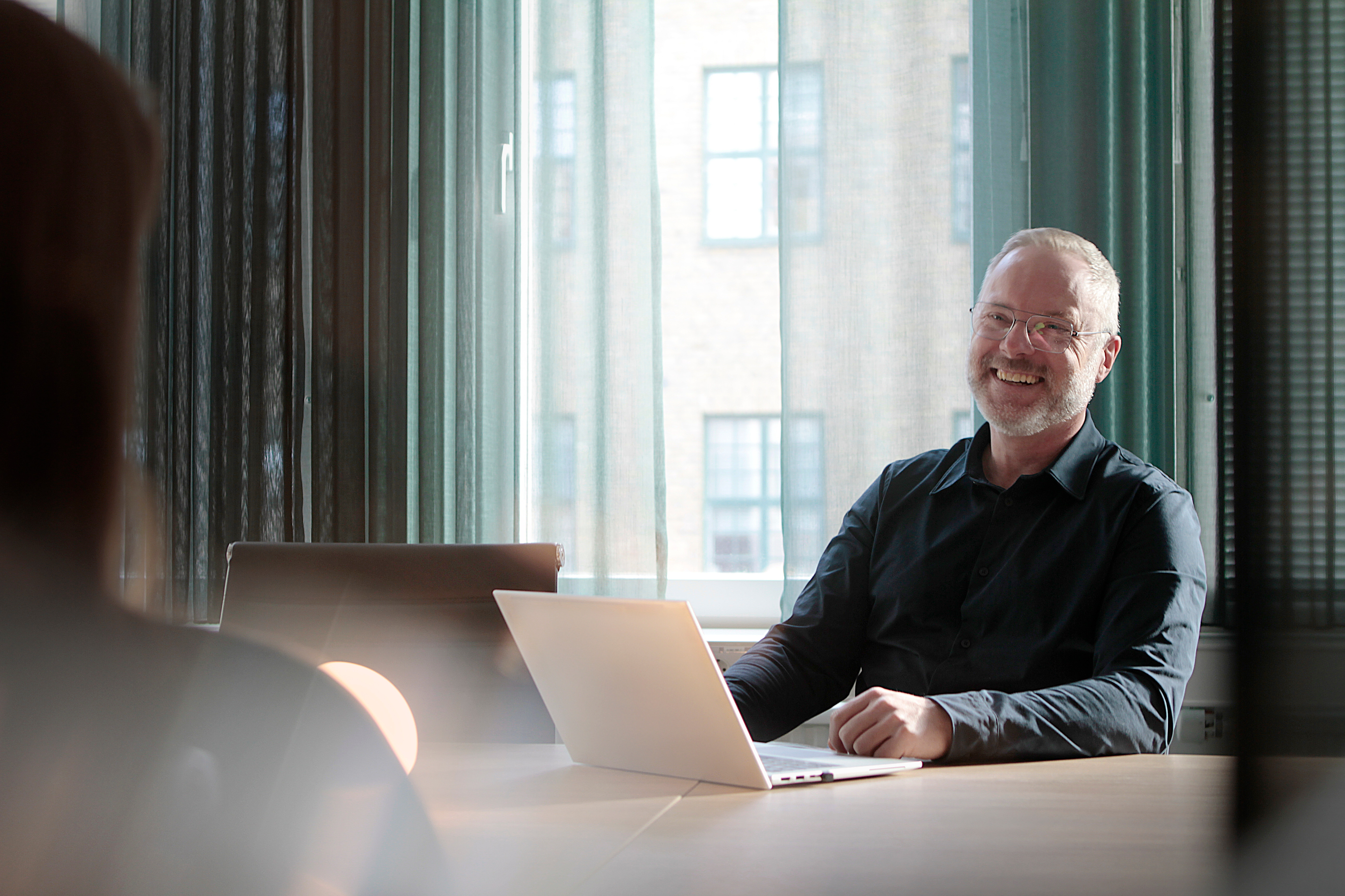 Man som sitter vid en dator och skrattar