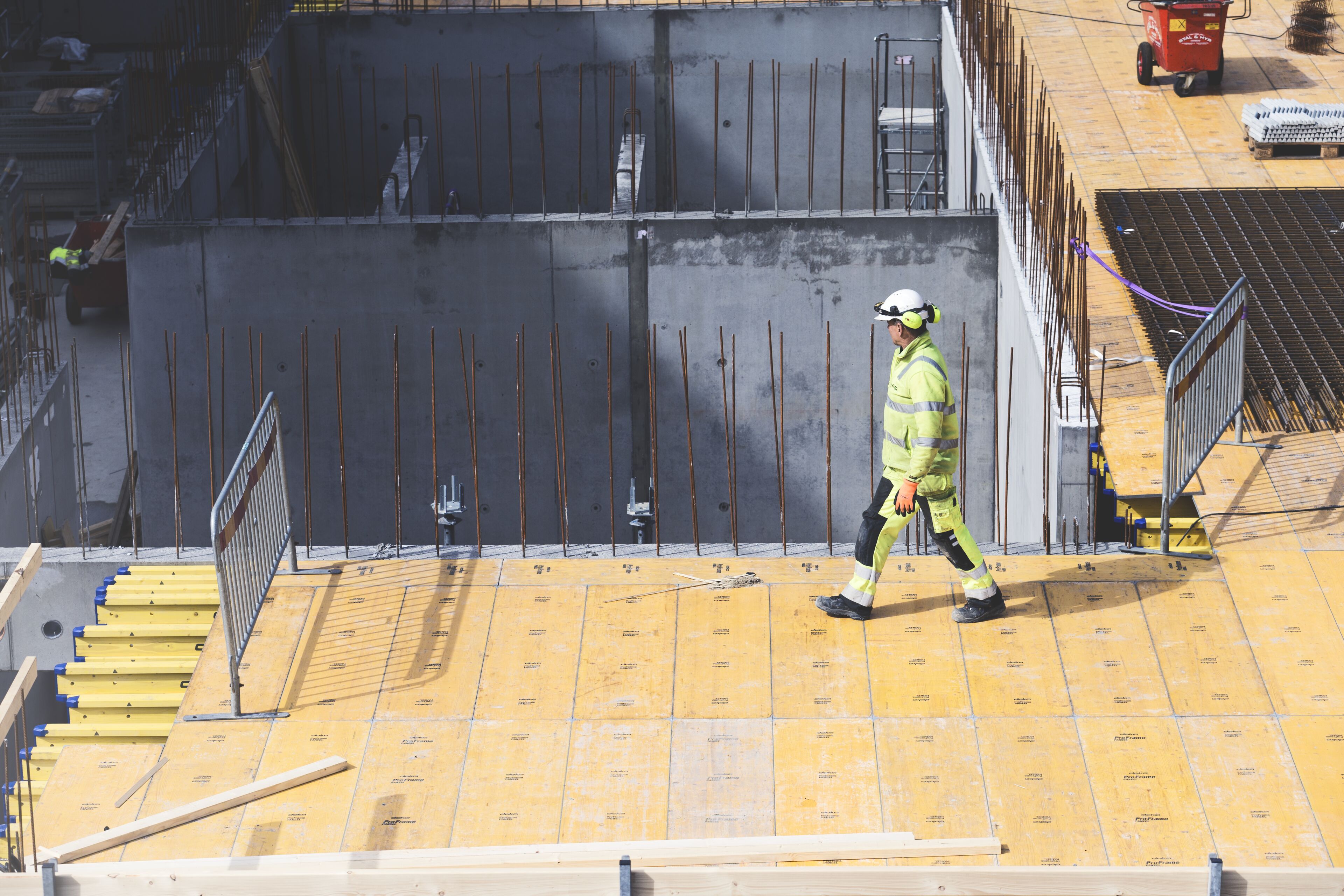 En Stena Stål anställd i bakgrunden som inspekterar material som är i förgrunden