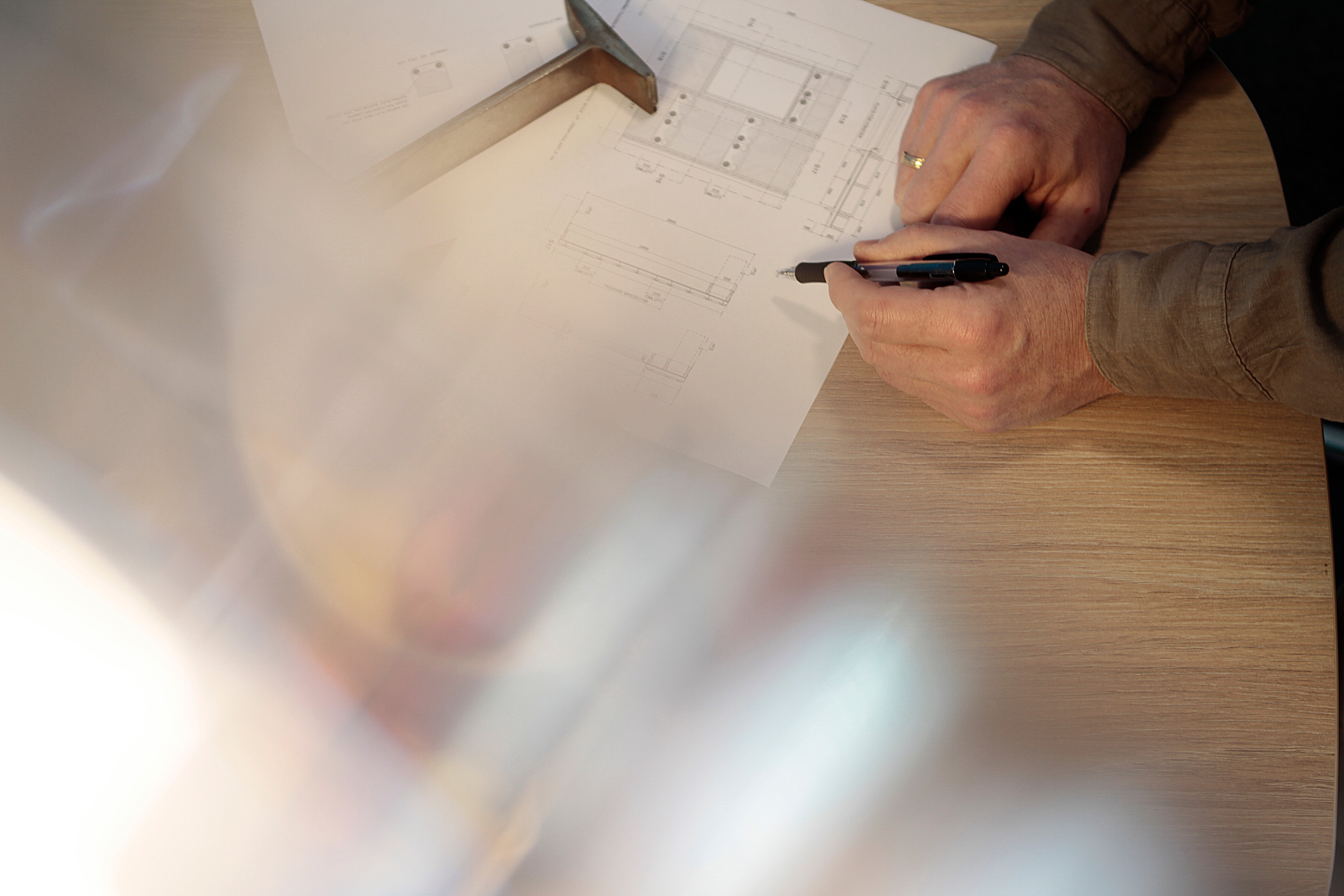 En person som antecknar på ritningar.